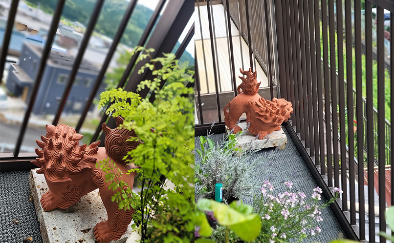 植栽のそばに設置された赤焼きシーサー
