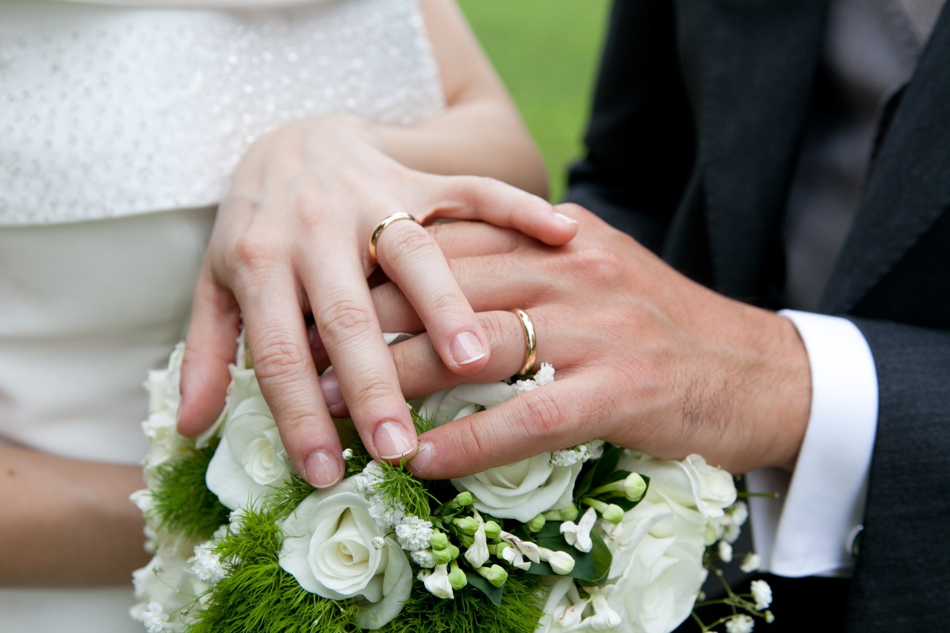 結婚指輪を重ねたふたりの手のイメージ