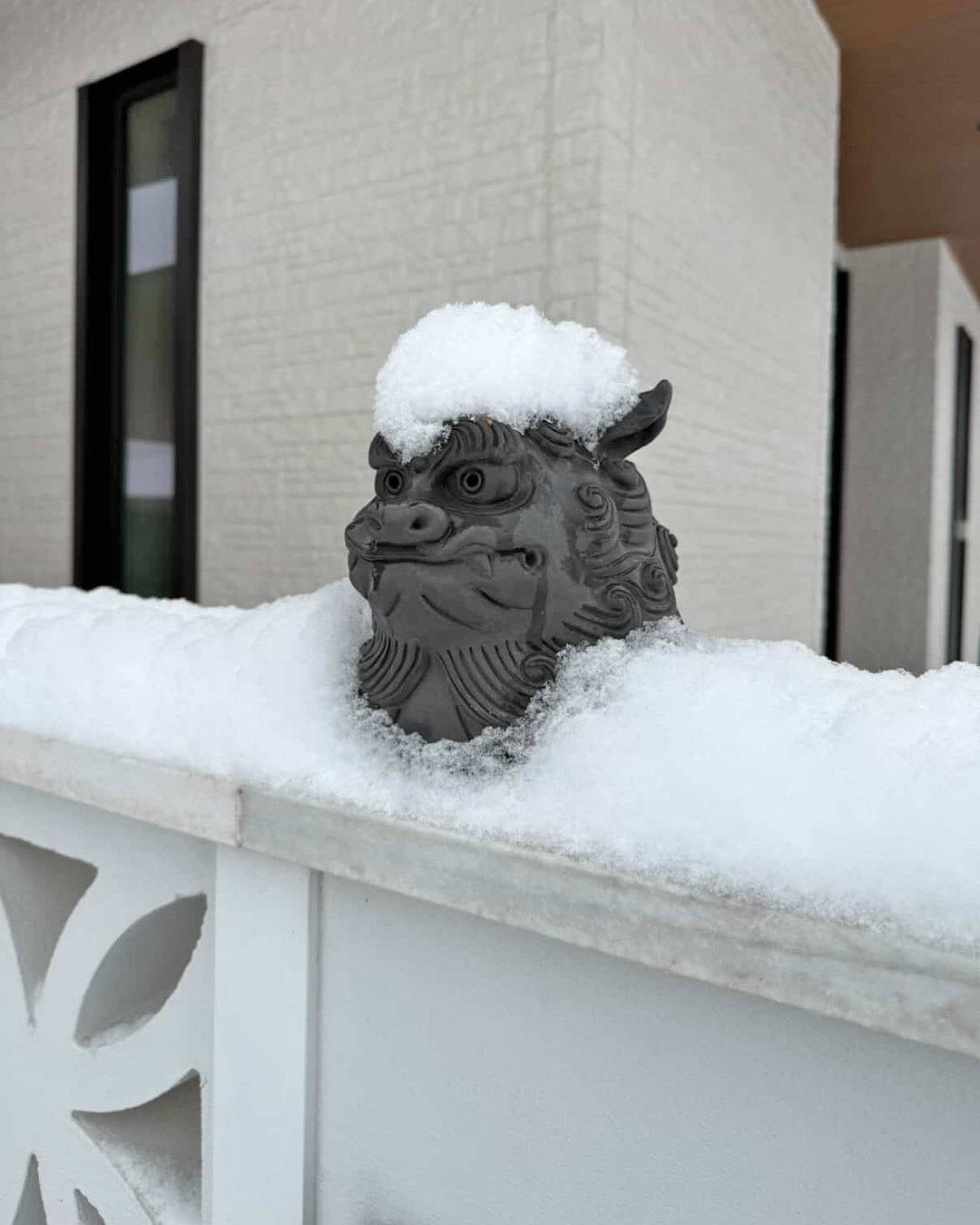 雪が積もる地域の門柱に置かれたシーサー